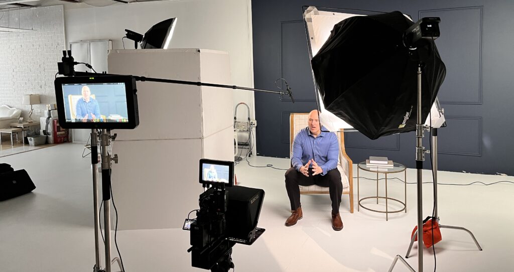 Using Video Marketing to Strengthen Your Business in 2026, A picture of someone sitting on a chair being filmed in a a studio